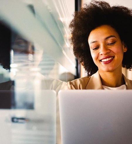 Young woman in online meeting on laptop smiling