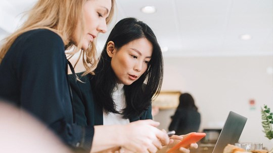 Colleagues use mobile phones during conferences in offices